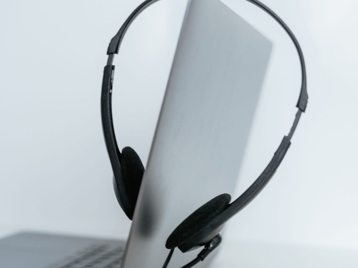 Illustrative photo: a customer-care headset resting on an open laptop